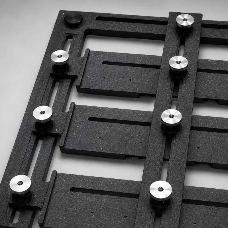 Adjustable universal composite pallet fixture showing custom track slider slots and locking knobs